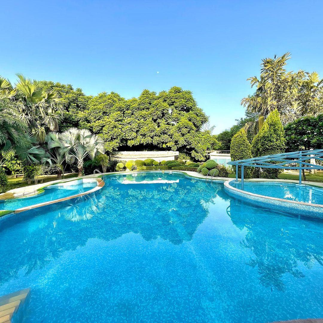 A scenic landscape featuring lush greenery, modern architecture, and a clear blue sky at Botanix Nature Resort.
